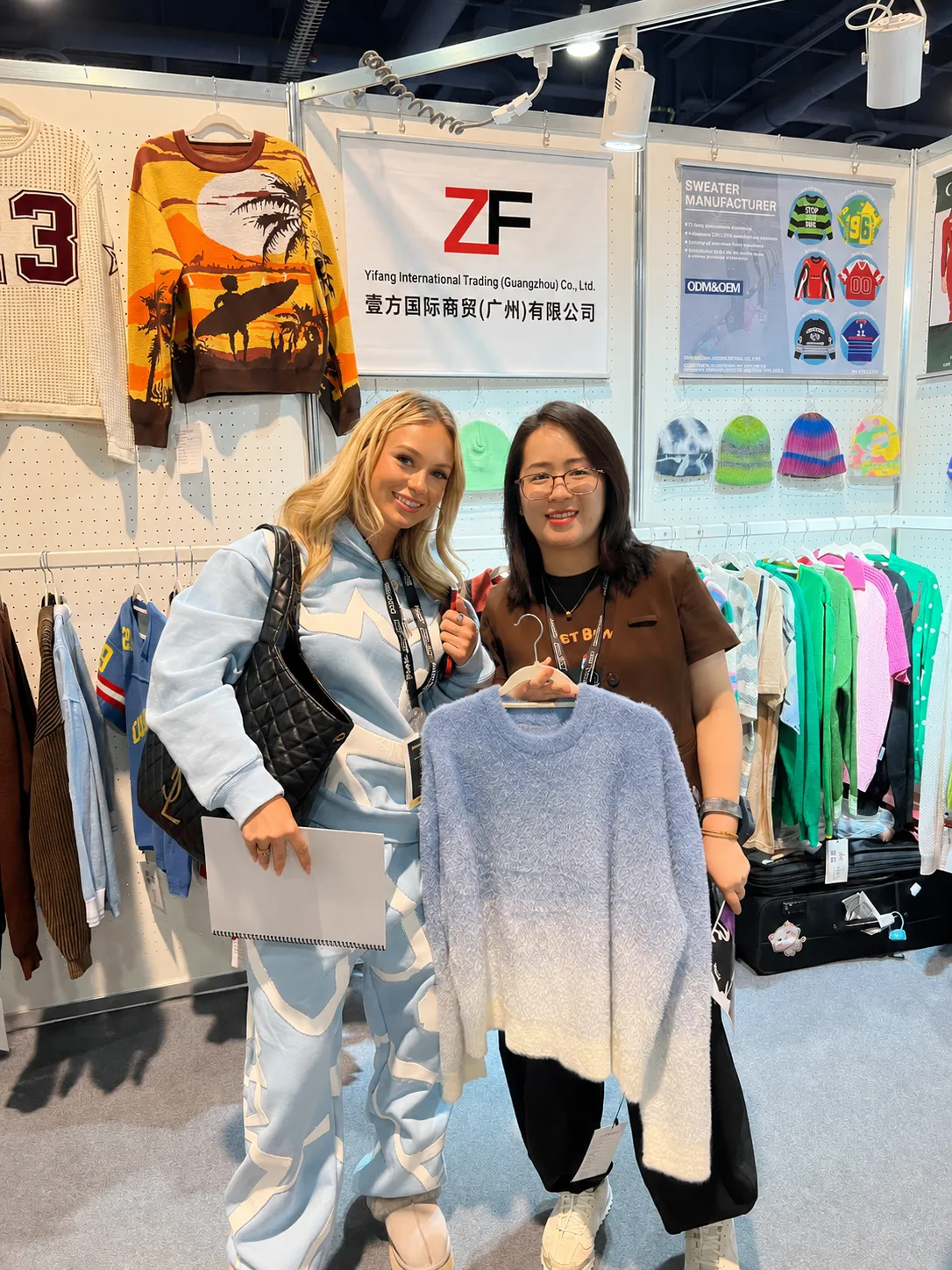 Overseas buyer discussing custom sweater production with knitwear manufacturer at sourcing exhibition