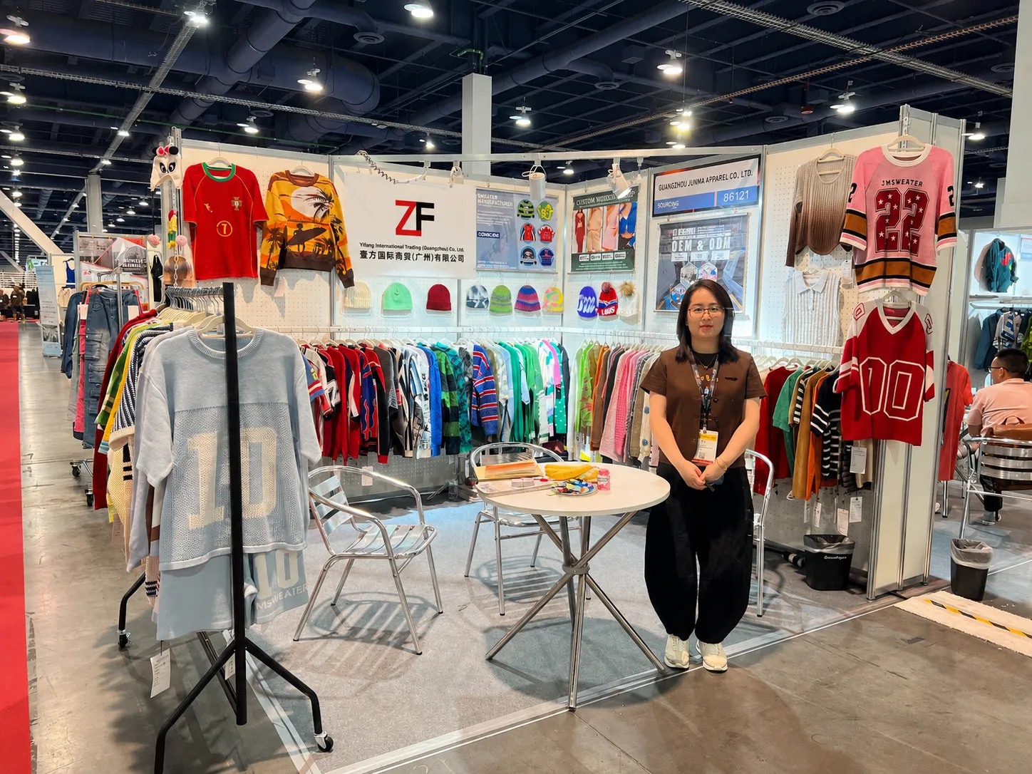 Professional knitwear manufacturer booth displaying custom sweaters and knitwear products at international trade show