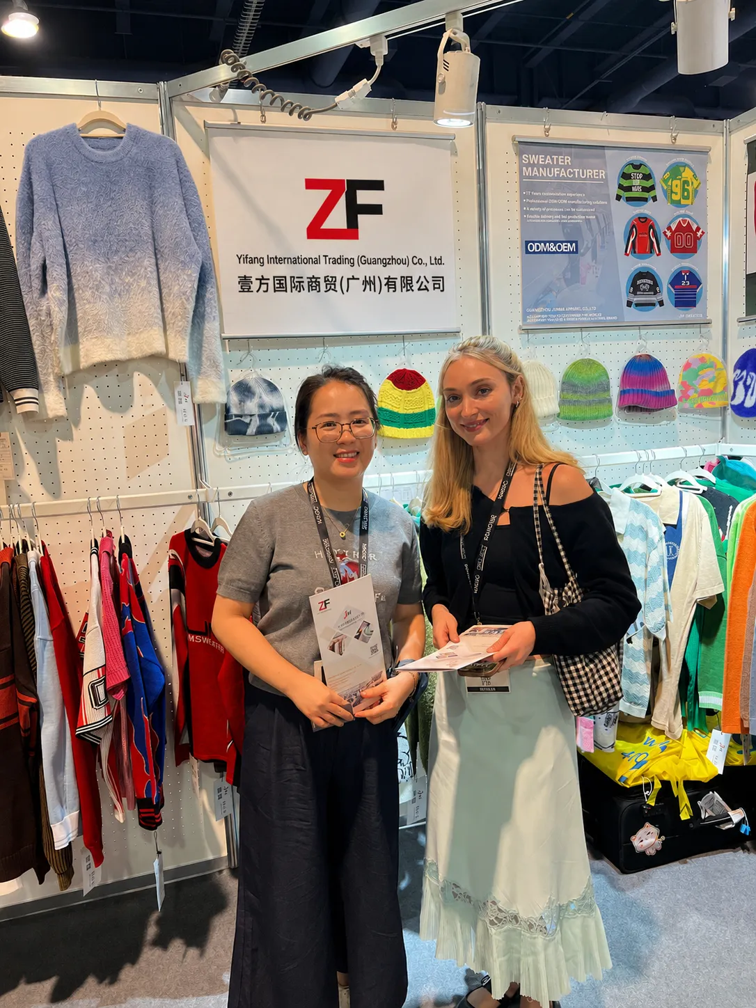 International customer visiting custom knitwear manufacturer booth during sourcing exhibition